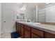 Bright bathroom featuring a double sink vanity, tile countertops, and a bathtub with a decorative shower curtain at 7440 E Osage Ave, Mesa, AZ 85212