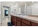 Bright bathroom featuring a double sink vanity, tile countertops, and a bathtub with a decorative shower curtain at 7440 E Osage Ave, Mesa, AZ 85212