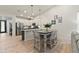 Bright dining area with modern light fixtures, light colored walls, and wood-style tile flooring at 7440 E Osage Ave, Mesa, AZ 85212
