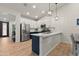 Modern kitchen featuring white cabinets, stainless steel appliances, a spacious island, and stylish pendant lighting at 7440 E Osage Ave, Mesa, AZ 85212