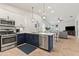 Open-concept kitchen featuring stainless steel appliances, contrasting cabinetry, quartz countertops, and pendant lighting at 7440 E Osage Ave, Mesa, AZ 85212