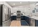 Well-lit kitchen equipped with stainless steel appliances, blue lower cabinets, and white upper cabinets at 7440 E Osage Ave, Mesa, AZ 85212