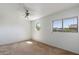 This bedroom features unique geometric window, modern ceiling fan, and neutral carpet at 7500 E Deer Valley Rd # 54, Scottsdale, AZ 85255