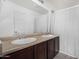 Bathroom featuring dual sinks, a large mirror, and a shower-tub combination with white shower curtain at 7732 W Bonitos Dr, Phoenix, AZ 85035