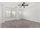 Spacious bedroom features neutral carpet, white walls, three windows, and a ceiling fan at 7732 W Bonitos Dr, Phoenix, AZ 85035
