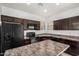 Kitchen featuring dark cabinets, an island, and stainless steel appliances at 7732 W Bonitos Dr, Phoenix, AZ 85035