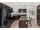 Kitchen featuring dark cabinets, an island, and a refrigerator at 7732 W Bonitos Dr, Phoenix, AZ 85035