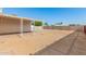 Large backyard featuring a covered patio, expansive dirt area, and privacy fencing at 7849 E Golf Ave, Mesa, AZ 85209