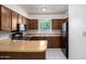 Well-lit kitchen featuring dark wood cabinetry, tile flooring, and a breakfast bar at 7849 E Golf Ave, Mesa, AZ 85209
