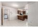 Functional kitchen featuring a breakfast bar, tiled floor, and view of the laundry room at 7849 E Golf Ave, Mesa, AZ 85209