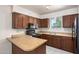 Well-lit kitchen featuring dark wood cabinetry, tile flooring, and a breakfast bar at 7849 E Golf Ave, Mesa, AZ 85209