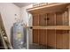 Practical utility room featuring a water heater and shelving for organized storage at 7849 E Golf Ave, Mesa, AZ 85209