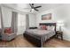 Spacious bedroom with a ceiling fan, a big window, and a comfortable chair at 8209 S 23Rd Pl, Phoenix, AZ 85042