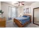 Bedroom with a ceiling fan, a big mirror, and a comfortable looking bed at 8209 S 23Rd Pl, Phoenix, AZ 85042