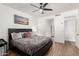 Primary bedroom with a ceiling fan, artwork and an attached ensuite bathroom at 8209 S 23Rd Pl, Phoenix, AZ 85042