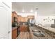 Kitchen featuring granite countertops, wood cabinets, and stainless steel appliances at 8209 S 23Rd Pl, Phoenix, AZ 85042