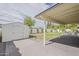 Backyard featuring a covered patio, storage shed, and a spacious grassy area at 8320 E Monte Vista Rd, Scottsdale, AZ 85257
