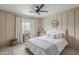 This cozy bedroom showcases neutral tones, a ceiling fan, and a window for natural light at 8320 E Monte Vista Rd, Scottsdale, AZ 85257