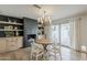 Charming dining area with a round wooden table, stylish light fixture, fireplace and sliding glass doors to the patio at 8320 E Monte Vista Rd, Scottsdale, AZ 85257