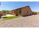 Rear exterior of home with covered patio, gravel landscaping, and small patch of artificial grass at 8541 W Malapai Dr, Peoria, AZ 85345