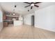 Open-concept living room with tile flooring, ceiling fan, and kitchen view at 8541 W Malapai Dr, Peoria, AZ 85345