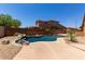 Backyard oasis featuring a stunning pool, rock waterfall, and desert landscaping at 8541 W Malapai Dr, Peoria, AZ 85345