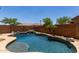Serene pool with rock accents and lush desert landscaping, perfect for relaxation and recreation at 8541 W Malapai Dr, Peoria, AZ 85345