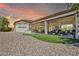 Backyard featuring desert landscaping, artificial turf, and a covered patio with outdoor kitchen at 9225 W Bajada Rd, Peoria, AZ 85383