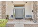 Inviting front entry with double doors, stone columns, neutral paint and a covered porch with seating at 9225 W Bajada Rd, Peoria, AZ 85383