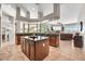 Open kitchen with a center island, dark wood cabinets, granite countertops, and seamless access to living spaces at 9225 W Bajada Rd, Peoria, AZ 85383