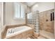 Well-lit bathroom features glass block shower and relaxing tub at 9225 W Bajada Rd, Peoria, AZ 85383