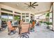Inviting covered patio with a ceiling fan, dining set, grill, and a view of the landscaped backyard at 9225 W Bajada Rd, Peoria, AZ 85383