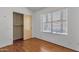 Cozy bedroom featuring laminate floors, window with blinds, and closet for storage at 9601 S 44Th St, Phoenix, AZ 85044