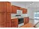 Functional kitchen boasts laminate floors, light wood cabinets, white appliances, and access to the patio at 9601 S 44Th St, Phoenix, AZ 85044