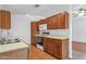 Functional kitchen with laminate floors, light wood cabinets, white appliances, and tiled countertops at 9601 S 44Th St, Phoenix, AZ 85044