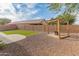 Landscaped backyard with artificial turf, a pergola, and gravel for low maintenance at 10226 N 93Rd Dr, Peoria, AZ 85345