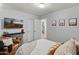A comfortable bedroom with a chair, flatscreen, closet, and ensuite door. Decorated with framed prints at 10226 N 93Rd Dr, Peoria, AZ 85345