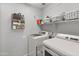 Convenient laundry room with modern washer, dryer, and shelving for organized storage solutions at 10226 N 93Rd Dr, Peoria, AZ 85345