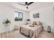 Cozy bedroom features a ceiling fan, stylish decor, a window with natural light, and wood-look floors at 11025 E Cholla Rd, Mesa, AZ 85207