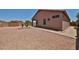 Back exterior of the home with desert landscaping and a wooden gate at 11038 W Oraibi Dr, Peoria, AZ 85373