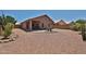 Wide backyard features desert landscaping, a covered patio, and privacy walls at 11038 W Oraibi Dr, Peoria, AZ 85373