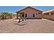 Back exterior of the home with desert landscaping and a covered patio at 11038 W Oraibi Dr, Peoria, AZ 85373