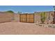 Backyard with desert landscaping and a gate to access the community at 11038 W Oraibi Dr, Peoria, AZ 85373