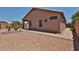 Back exterior of the home with desert landscaping and a covered patio at 11038 W Oraibi Dr, Peoria, AZ 85373