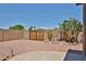 Backyard featuring desert landscaping, patio, and wooden privacy gate at 11038 W Oraibi Dr, Peoria, AZ 85373