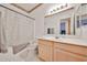 Bathroom featuring a wooden vanity with a large mirror, and a shower-tub combination at 11038 W Oraibi Dr, Peoria, AZ 85373