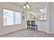 Bright dining area featuring wood-look floors, light fixture, and a breakfast bar leading to the kitchen at 11038 W Oraibi Dr, Peoria, AZ 85373
