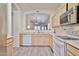 Open kitchen layout with stainless appliances, light cabinets, and pass through to living area at 11038 W Oraibi Dr, Peoria, AZ 85373