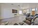 Bright living room with wood floors, neutral colors, and an open layout to the kitchen at 11038 W Oraibi Dr, Peoria, AZ 85373
