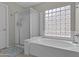 Bathroom featuring soaking tub, glass block window, and separate shower with glass door at 1162 E Ranch Ct, Gilbert, AZ 85296